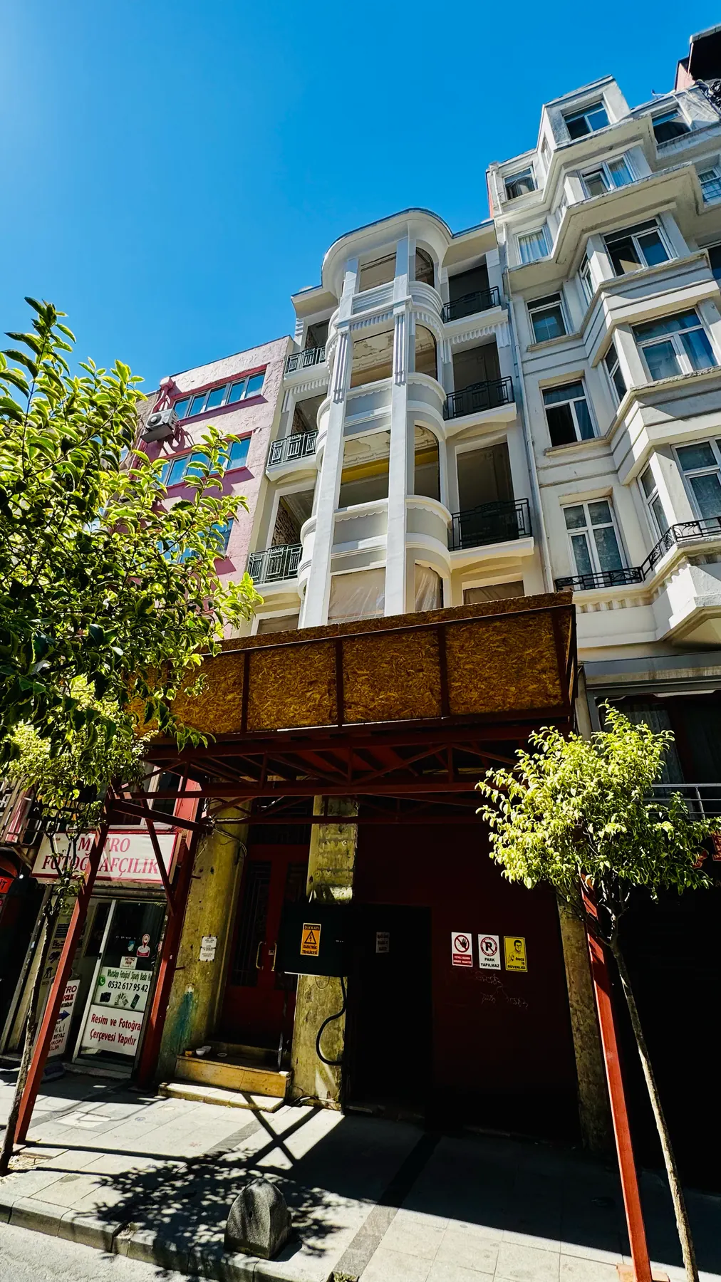Cephenin ağaçların arasından görünüşü: balkonlar ve kat silmeleri