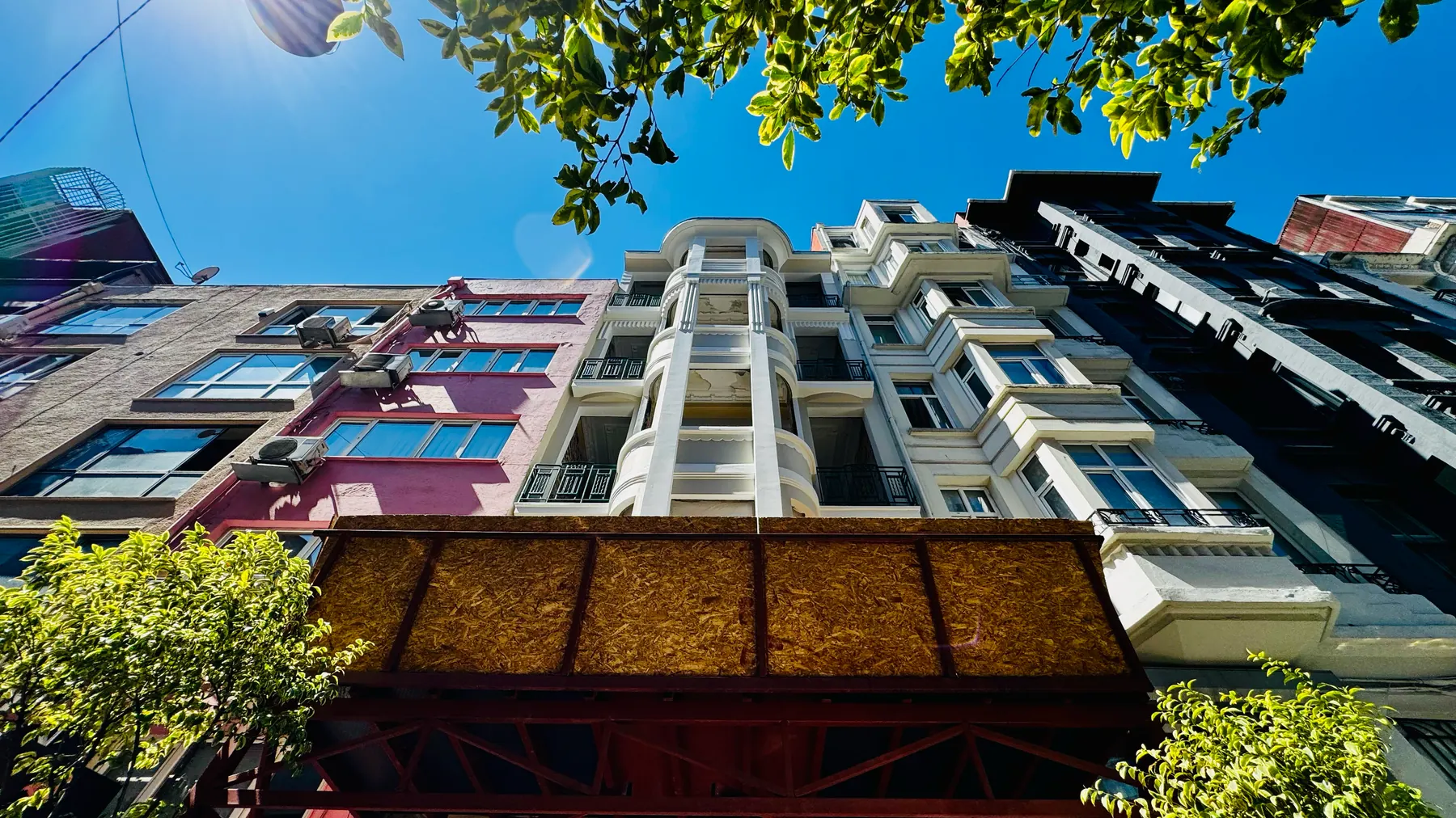 Cumbanın aşağıdan görünüşü: kat kat çıkan yuvarlak köşe ve demir balkon korkulukları