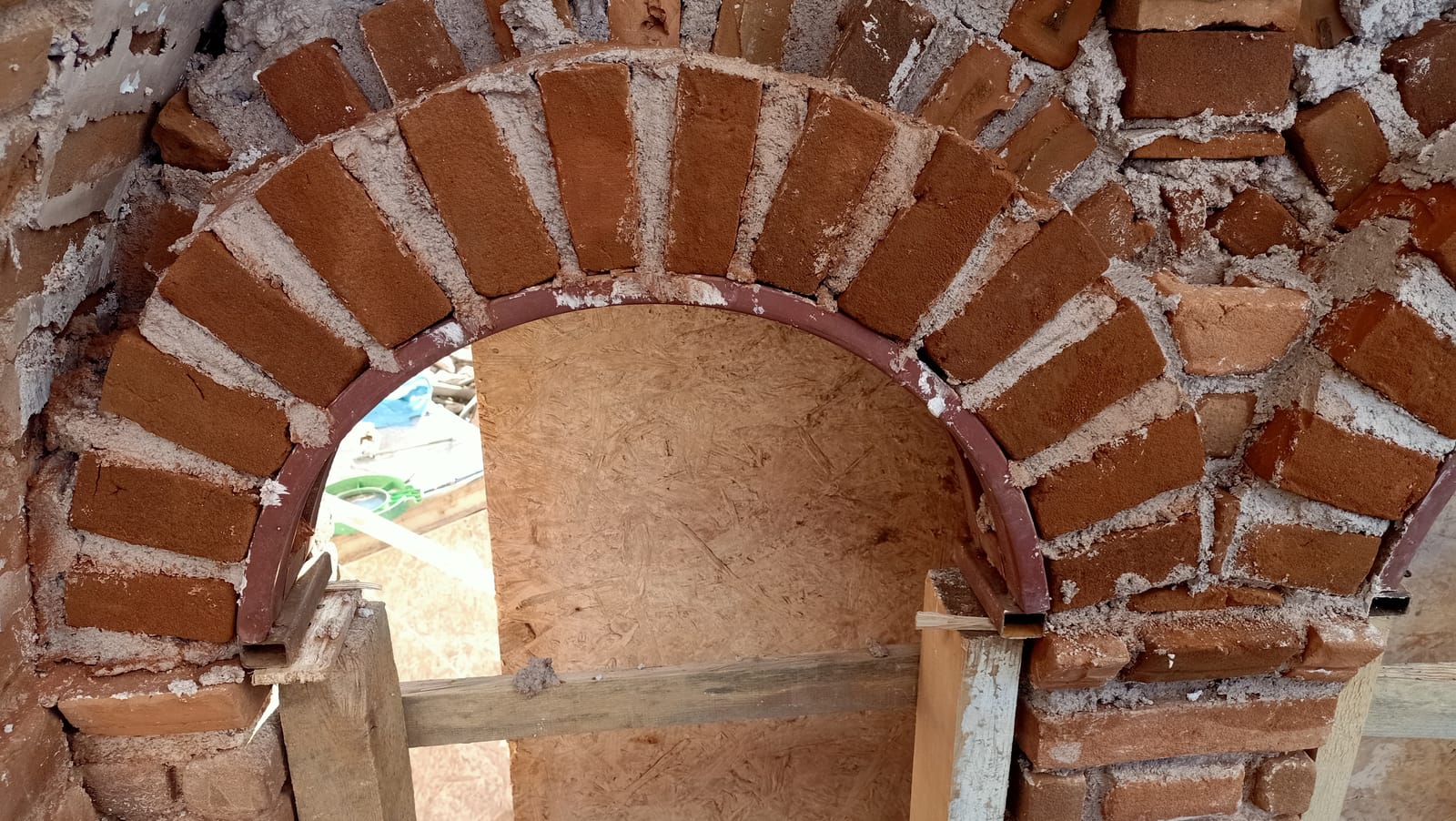 Açıklığın üstündeki tuğla kemer, ahşap kalıba yaslanarak örülmüş hâlde
