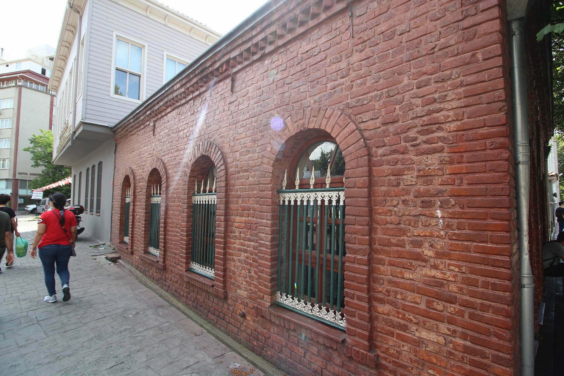 Türbenin sokağa bakan uzun tuğla duvarı ve kemerli pencere dizisi